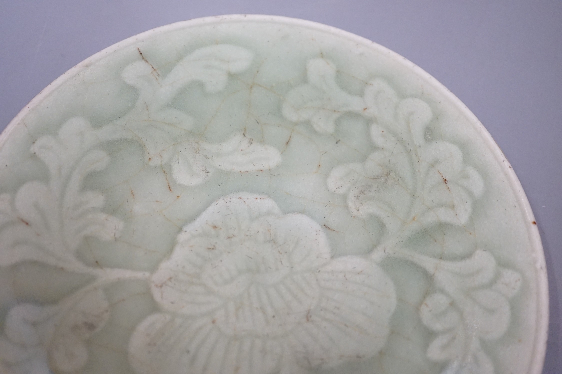 A Chinese carved celadon dish, Qing dynasty, 15cm diameter